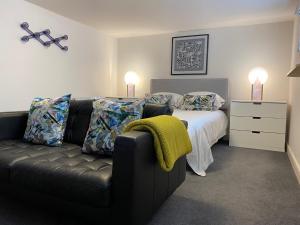 a bedroom with a couch and a bed with two lamps at Jays Bay Entire Luxury Apartment by the Beach Gt Yarmouth in Great Yarmouth