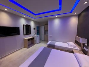 a hotel room with two beds and a tv and a room at Phaethon Apartments & Studios in Kallithea Halkidikis