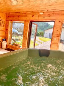 a large green tub in a room with windows at Casa Carmen in Dorna Arini