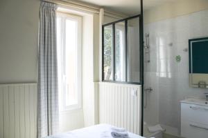 a bathroom with a shower and a toilet and a window at Mon P'tit Hôtel in Le Grau-dʼAgde