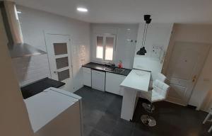 a white kitchen with a sink and a counter at La Casita in Málaga