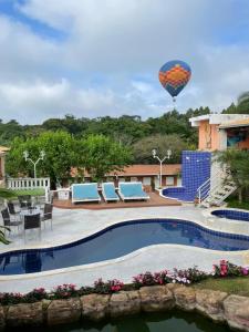 a hot air balloon flying over a swimming pool at Pousada Villa São Francisco in Boituva