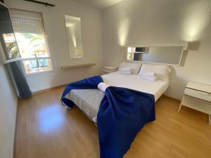 Un dormitorio con una cama con una manta azul. en Las Lomas - Apartamentos, en Costa Calma
