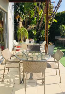 a patio with a glass table and chairs at The One 8 Hotel in Green Point - Solar Power in Cape Town