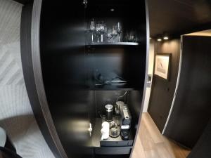 a black cabinet with a coffee maker and glasses at San Carlo Suite in Lugano