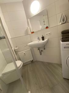 La salle de bains est pourvue de toilettes et d'un lavabo. dans l'établissement Exklusiv, modernes Apartment mit Balkon, à Böblingen