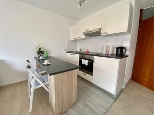 a kitchen with white cabinets and a black counter top at Exklusiv, modernes Apartment mit Balkon in Böblingen