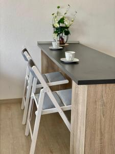 Exklusiv, modernes Apartment mit Balkon في بوبلينغين: طاولة وكراسي سوداء وبيضاء عليها كوبين