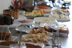 a table filled with plates of food and desserts at Hotel Nosso Bosque in Rio do Sul