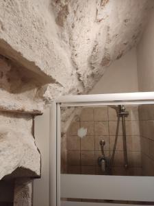 y baño con pared de piedra y ducha. en Minuetto 73, en Ostuni