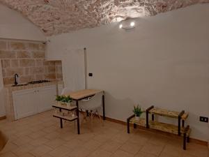 cocina con mesa, sillas y pared blanca en Minuetto 73, en Ostuni