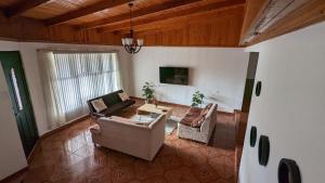 Sala de estar con 2 sofás y mesa en Villa Dreams Irazu, en Cartago