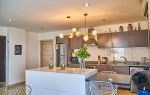 a kitchen with a counter and a table and chairs at The Gallery Luxury Suites CPG in East Legon