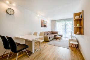 a living room with a table and chairs and a couch at MF SilverBeach 112 Apartment in Siófok