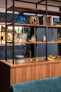 une étagère en bois avec des vases bleus et d'autres articles sur elle dans l'établissement Royal Saint Germain, à Paris