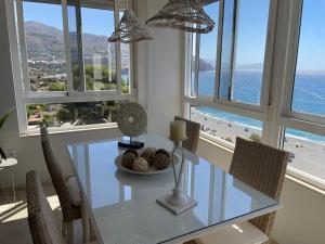 a dining room with a glass table and chairs at Velilla Apartment “Sun&Sea” in Almuñécar