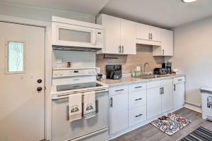 una cocina con armarios blancos y electrodomésticos blancos en Lovely Belle Center Cottage on Indian Lake!, en Belle Center