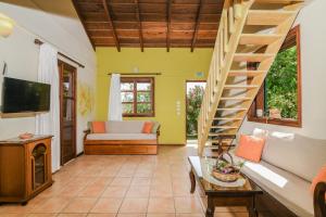 a living room with a couch and a staircase at Therianos Traditional Villas in Kallithea