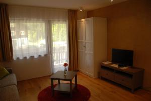 a living room with a couch and a television at Apartments Bischof in Schröcken