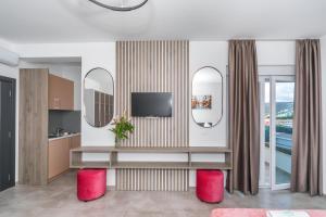 sala de estar con TV y 2 espejos en Zodea Apartments, en Dobra Voda