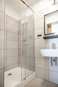 een badkamer met een douche en een wastafel bij Fotel Mikołowska in Tychy