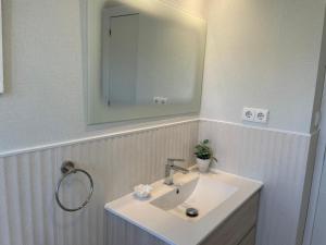 a bathroom with a white sink and a mirror at Velilla Apartment “Sun&Sea” in Almuñécar +15 photos