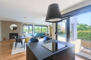 a kitchen and living room with a table and chairs at Luxury Villa Hedone with heated pool, welness and playground in Rakalj