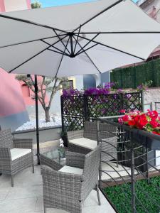 Aretusa Resort Amalfi Coast في فيتري: فناء فيه مظلة وكراسي وطاولة فيها ورد