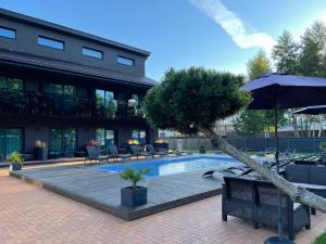 uma piscina com cadeiras e um guarda-sol ao lado de um edifício em SKY Villa em Palanga