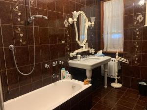 ein Badezimmer mit einem Waschbecken, einer Badewanne und einem Spiegel in der Unterkunft Villa Maximo in Albano Laziale