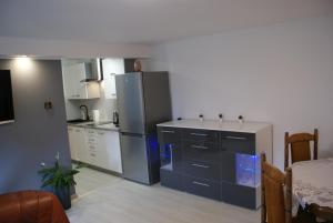 kuchnia ze stalową lodówką i stołem w obiekcie Apartament na Górce w Międzybrodziu Bialskim