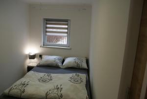 mała sypialnia z łóżkiem i oknem w obiekcie Apartament na Górce w Międzybrodziu Bialskim +17 zdjęć