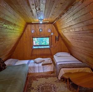 a bedroom with two beds in a wooden room at Vila Milovanovic TARA in Bajina Bašta