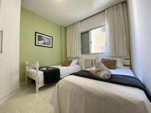 um quarto com 2 camas e uma janela em NVR62B - Quadra Mar, Sacada, 2 Dorm, Climatizado em Balneário Camboriú