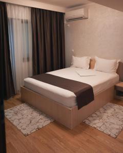 a large bed in a room with a window at Delta Est Hotel & Restaurant in Sulina