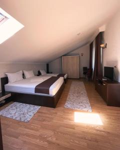 una camera con un letto e una televisione di Delta Est Hotel & Restaurant a Sulina