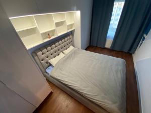 małe łóżko w pokoju z niebieskimi zasłonami w obiekcie BLUE SKY APARTMENT w Jurmale
