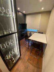 ユールマラにあるBLUE SKY APARTMENTの冷蔵庫、テーブル、椅子が備わる客室です。