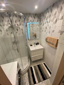 W łazience znajduje się szklana kabina prysznicowa i umywalka. w obiekcie BLUE SKY APARTMENT w Jurmale
