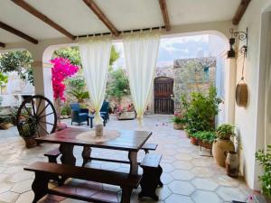 un patio al aire libre con mesa de madera y sillas en Masseria Salentina, en Marina Serra