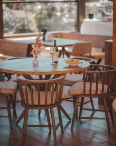 une table en bois avec des chaises et une table avec une boisson dans l'établissement Delta Est Hotel & Restaurant, à Sulina