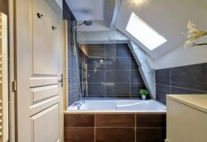 a bathroom with a bath tub in a attic at La Mansarde : Cosy et Charme au Centre Historique in Dijon +19 photos