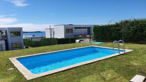 een zwembad in de tuin van een huis bij Modern 4 Double Bedroom Villa with Pool / Garden in Valdoviño