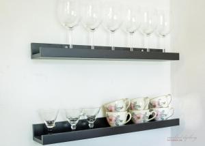 a shelf with wine glasses and cups on it at Ragnhilds Gård, Hostel Vandrerhjem in Nyord