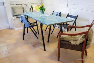a dining room table with chairs and a vase of flowers on it at Ragnhilds Gård, Hostel Vandrerhjem in Nyord +25 photos