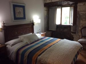 ein Schlafzimmer mit einem Bett mit einer bunten gestreiften Decke in der Unterkunft Caserío Maribel in Aprícano