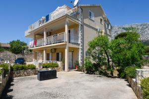 a large house with a balcony and a driveway at Apartments Sandra in Orebić