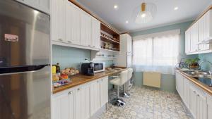 cocina con armarios blancos y nevera de acero inoxidable en Apartamentos Oncemolinos con desayuno, en Consuegra 37 fotos más