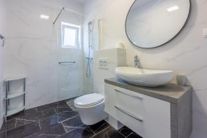 a bathroom with a sink and a toilet and a mirror at Apartman Dora in Crikvenica +22 photos