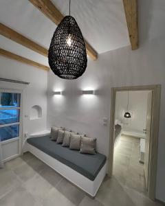 een kamer met een bed en een hanglamp bij Alidian bay Suites Leros in Alinda